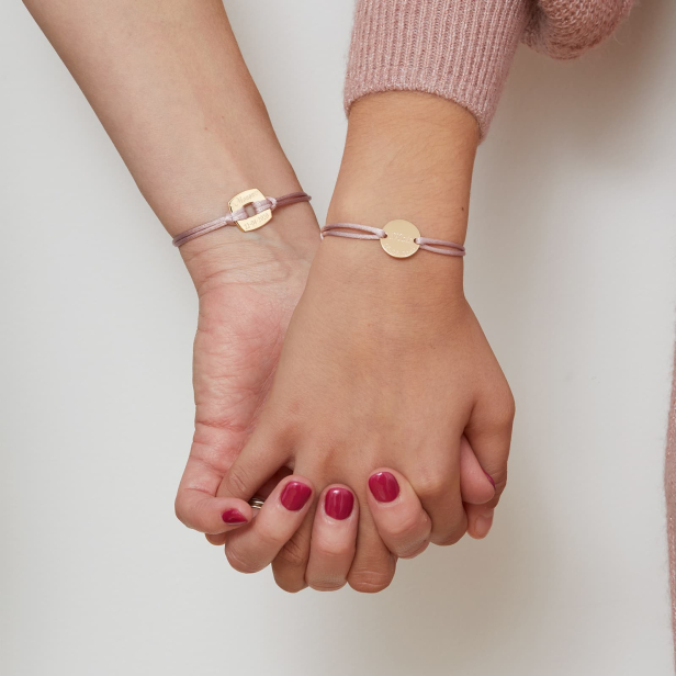 Porté du bracelet cordon personnalisé enfant avec médaille plaqué or