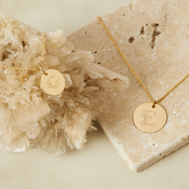 Nature morte colliers personnalisés pour enfant en plaqué or avec des initiales florales