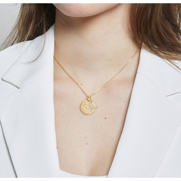 Collier personnalisé plaqué or avec une constellation gravée sur la médaille.